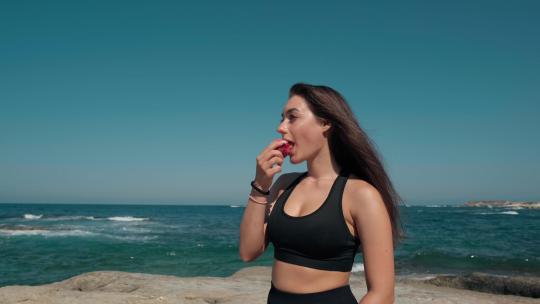 一女性在海边吃水果