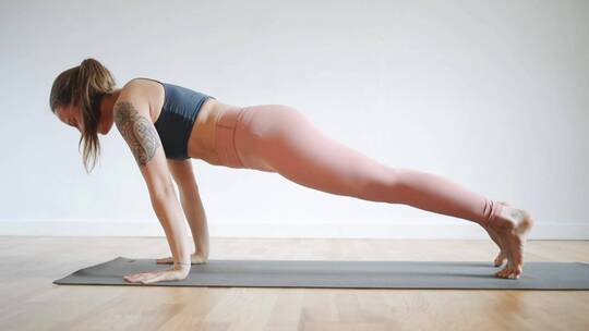 一个女人在她的瑜伽垫上做伸展运动