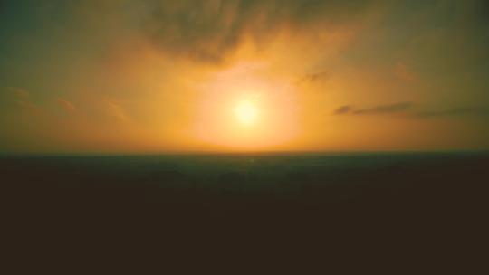 黄色天空中的日落。延时。明亮的黄色大太阳落下。令人敬畏的天空景观和