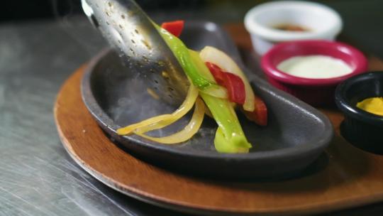 用勺子把煮熟的蔬菜放在盘子里