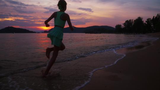 女孩在日落海滩边奔跑