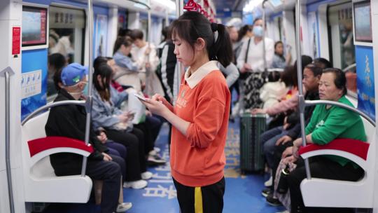 年轻女性地铁玩手机