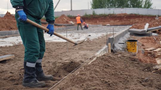 员工在工厂建筑工地投掷泥土