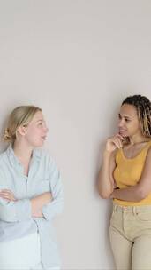 白墙前两个女人在互相交谈