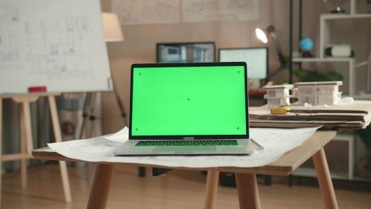 绿屏笔记本电脑的特写在建筑办公室的桌子上