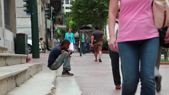 希腊，雅典，2013年6月7日：希腊雅典街头的乞丐和人们