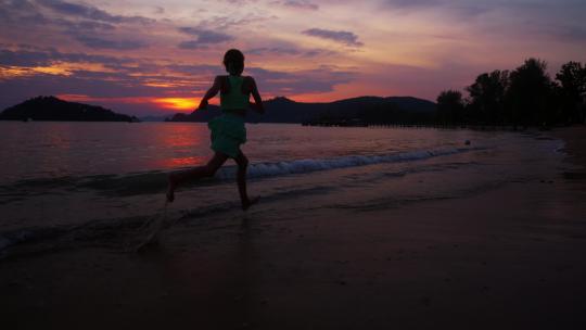 女孩在日落海滩边奔跑