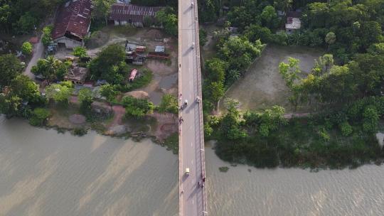 俯视图跟随车辆在孟加拉国泥泞河上的桥路行驶