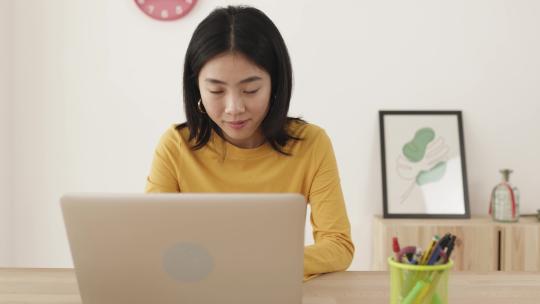 中国女人在家里使用笔记本电脑