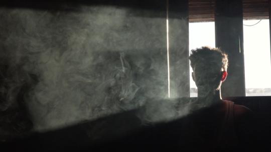 黑暗中被烟雾包围的男人视频素材模板下载