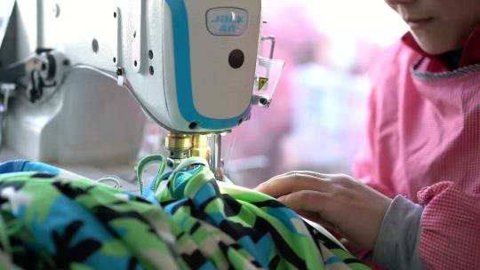 缝纫女工正在用缝纫机制作宠物狗服装