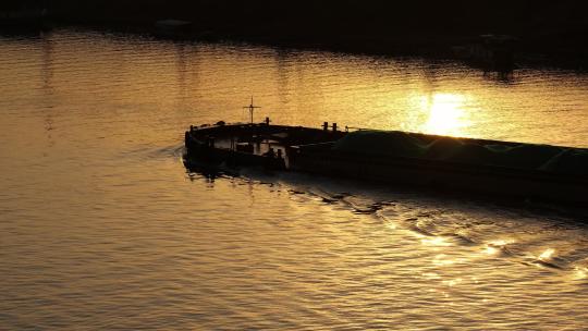 金色夕阳下货轮船河流逆光剪影