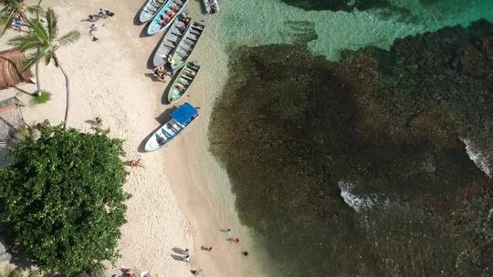 木船停泊在满满夏日风的碧绿海滩边