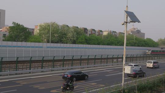 北京6号线地铁列车在地面行驶旁边是高速路