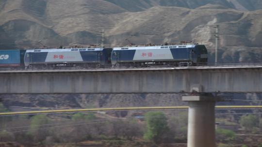 拉集装箱的货运火车快速经过黄河大桥