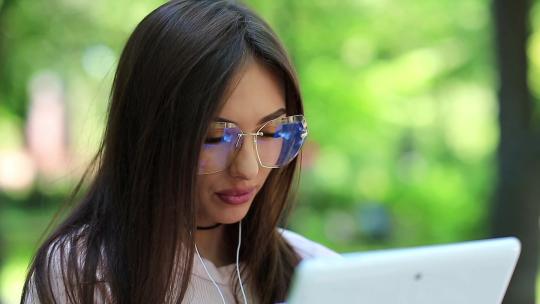 戴眼镜的女孩使用平板电脑