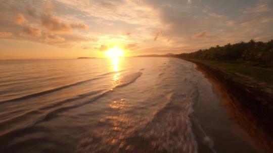 FPV航拍海上日落夕阳下的海岸海浪拍打岩石