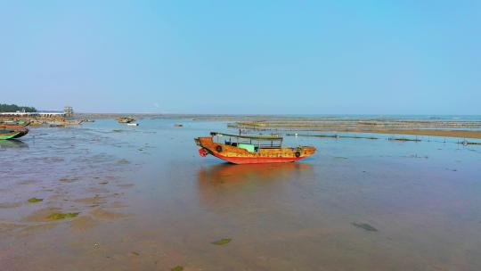 一艘停泊在海滩上的橘红色小船