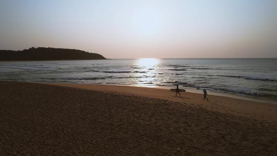 冲浪者在日出时到海上冲浪