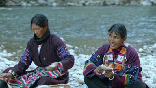 藏族妇女河边纺线劳作生活