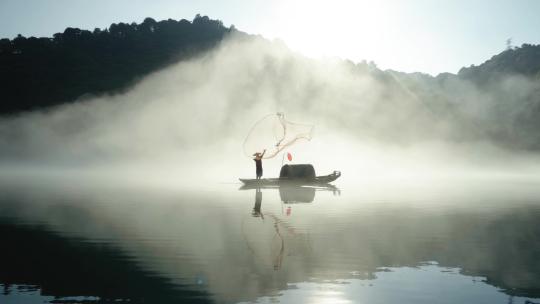 日出时渔民在雾气飘飘的江面撒网