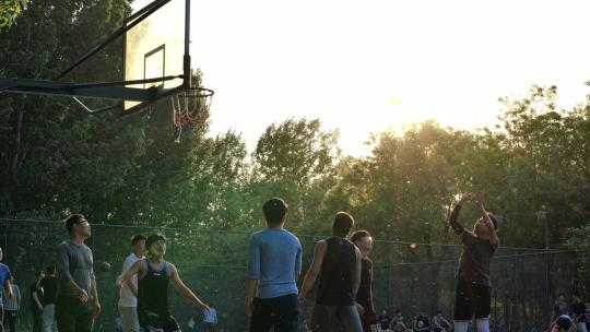 阳光下一群阳光快乐健康的年轻人在打篮球