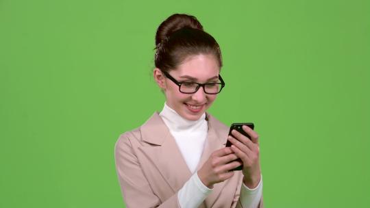 商务女士在智能手机上看照片。绿屏。慢动作