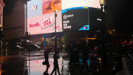 雨夜行人走在一个繁忙的城市街道