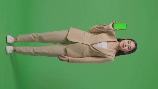 全身亚洲商务女性微笑在绿屏上显示绿屏手机
