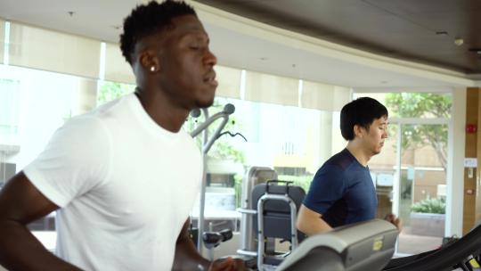 男性在健身房的跑步机上跑步
