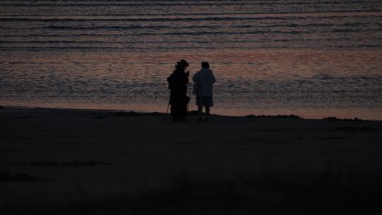 威海西海岸沙滩上看落日晚霞的游人