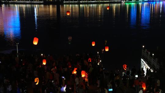 湖北襄阳节日旅游燃烧孔明灯的游客人群