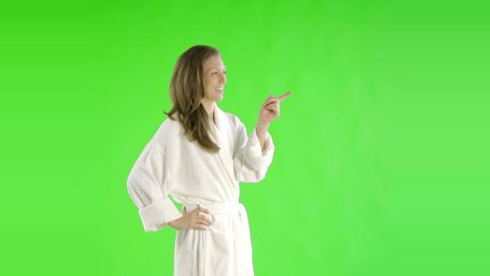 穿着浴袍的女人站在绿幕前视频素材模板下载