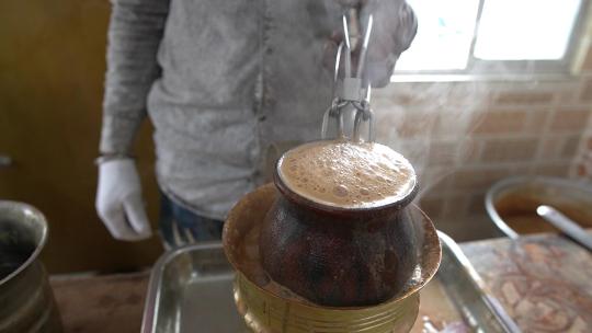 印度街头食品小贩在热粘土中煮沸制作坦杜里马萨拉茶的特写镜头