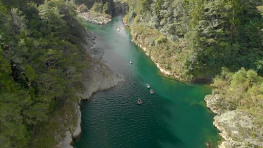 独木舟旅游中的人划桨美丽原始透明的蓝色佩鲁斯河，新西兰——无人机