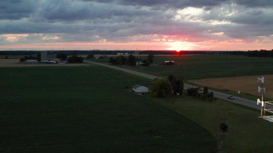 日落时分，密歇根农村的农场筒仓上挥舞着美国国旗，无人机视频移动着