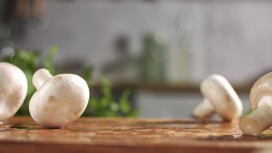 滴着水新鲜蘑菇落在木板上特写