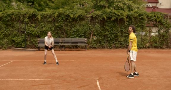 一对夫妇在网球户外球场打网球