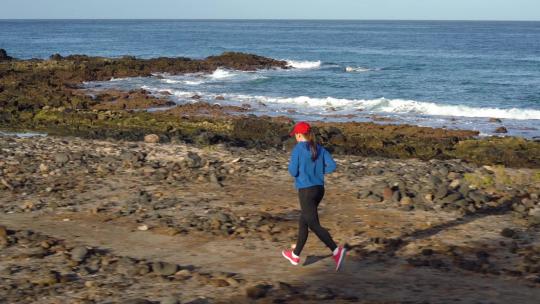 女人沿着大海海岸奔跑