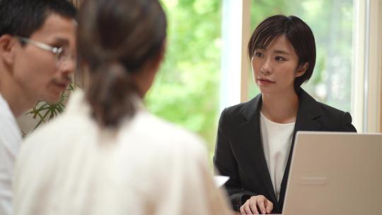 一名女性在电脑前和顾客交谈