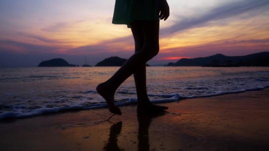 女孩在日落海滩边行走