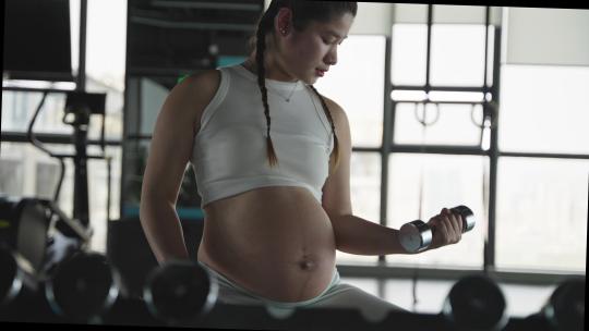 怀孕的现代女性在健身房锻炼身体