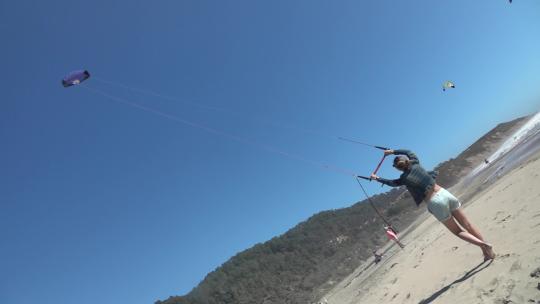 一个女人在沙滩上玩滑翔伞