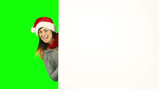绿幕上带着圣诞帽子的女人指向白色海报