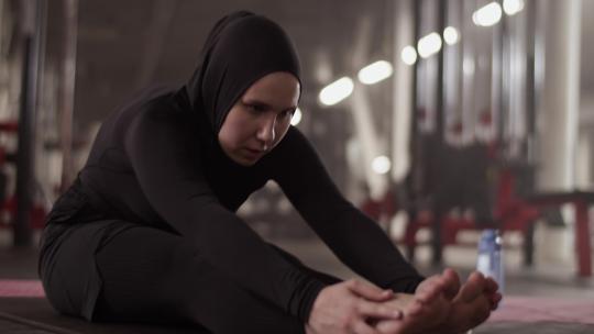 穆斯林女运动员热身在健身房