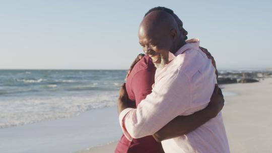 非裔美国人父亲和成年儿子在海滩上拥抱的视频
