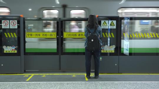 孤独的女孩背影在地铁站等候