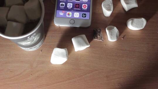 桌上放着棉花糖和智能手机