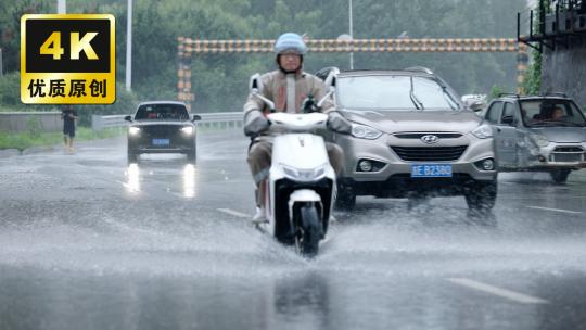 暴雨天气外卖骑手骑车冒雨奔波送餐的外卖员