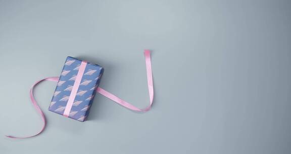 在包装好的礼物上系一条粉红色的丝带